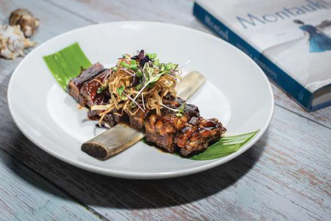 Smoked short rib with crisp shallots, plated on a banana leaf