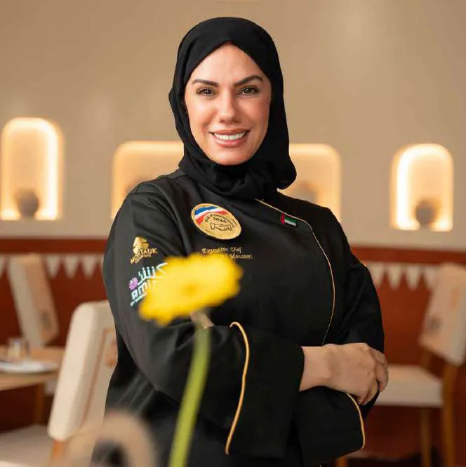 Chef Mariam with a yellow flower, in Amina uniform